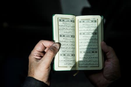 An Iranian pilgrim reads the Koran as she departs for the annual haj pilgrimage to the holy city of Mecca, at the Imam Khomeini Airport in Tehran, Iran, July 31, 2017. Nazanin Tabatabaee Yazdi/TIMA via REUTERS