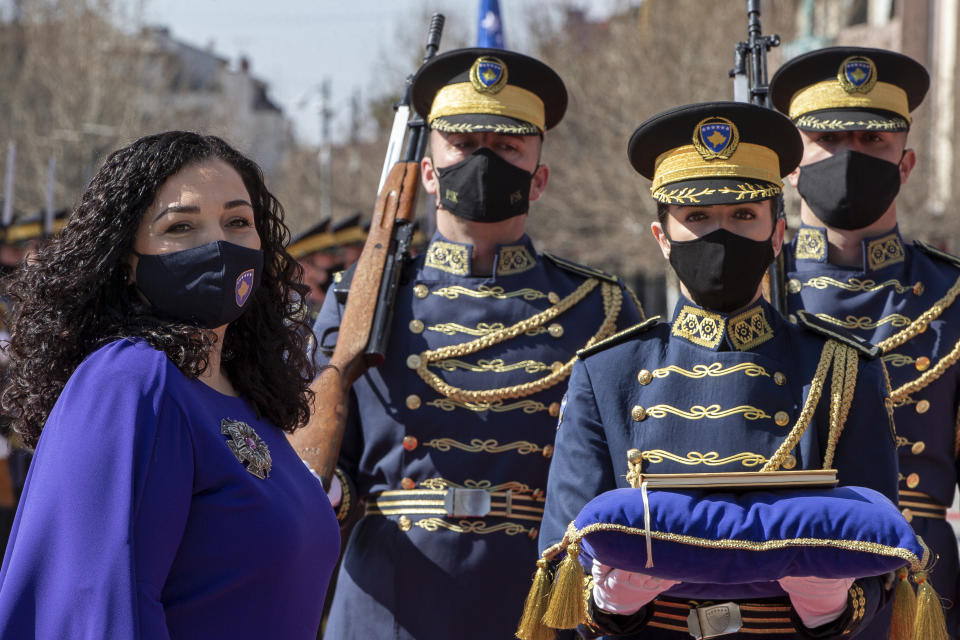 Kosovo newly elected president Vjosa Osmani-Sadriu, as Guard of Honour presents the Kosovo Constitution during a presidential hand over ceremony in capital Pristina, Kosovo, on Tuesday, April 6, 2021. 38-year old Osmani took over the presidency after being elected to the post during a two-day extraordinary session of parliament. (AP Photo/ Visar Kryeziu)