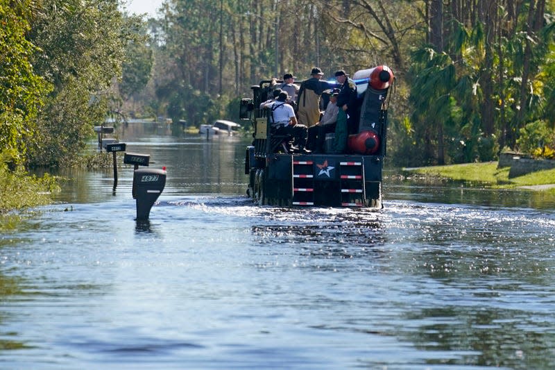 A high water vehicle with responders drives through a flooded neighborhood in the aftermath of Hurricane Ian in North Port, Florida, Monday, Oct. 3, 2022