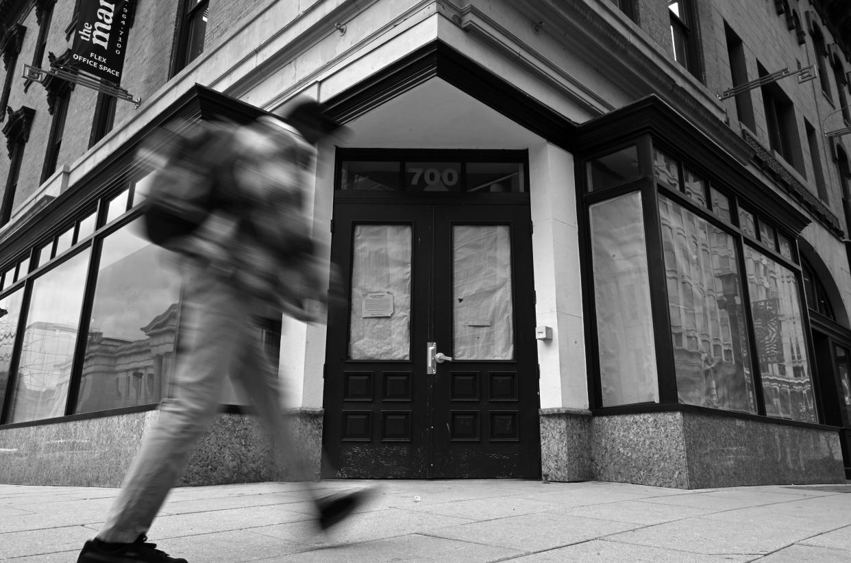 A pedestrian walks past an empty storefront in Washington, D.C. 