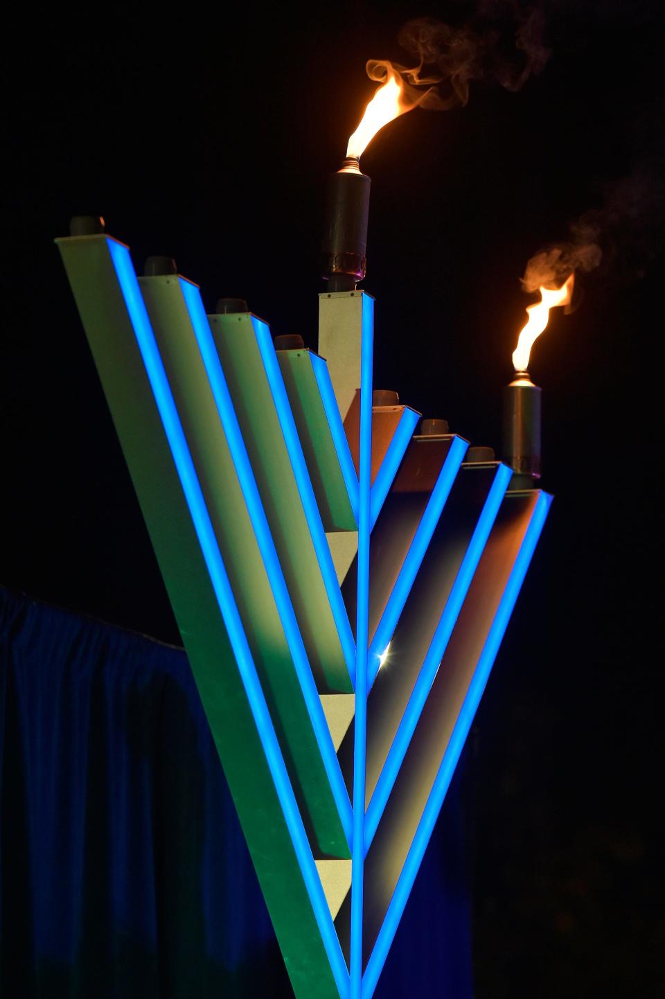 The center candle and the candle representing the first of the 8 nights of Hanukkah flicker atop the menorah.
