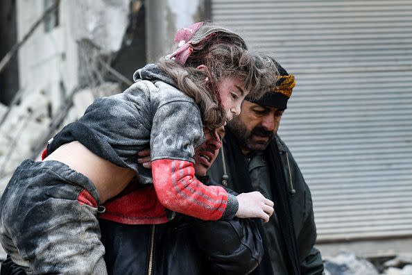 Residents carry an injured child from the rubble of a collapsed building following an earthquake in the town of Jandaris, in the countryside of Syria's northwestern city of Afrin in the rebel-held part of Aleppo province, on February 6, 2023. - Hundreds have been reportedly killed in north Syria after a 7.8-magnitude earthquake that originated in Turkey and was felt across neighboring countries. (Photo by Rami al SAYED / AFP) (Photo by RAMI AL SAYED/AFP via Getty Images)