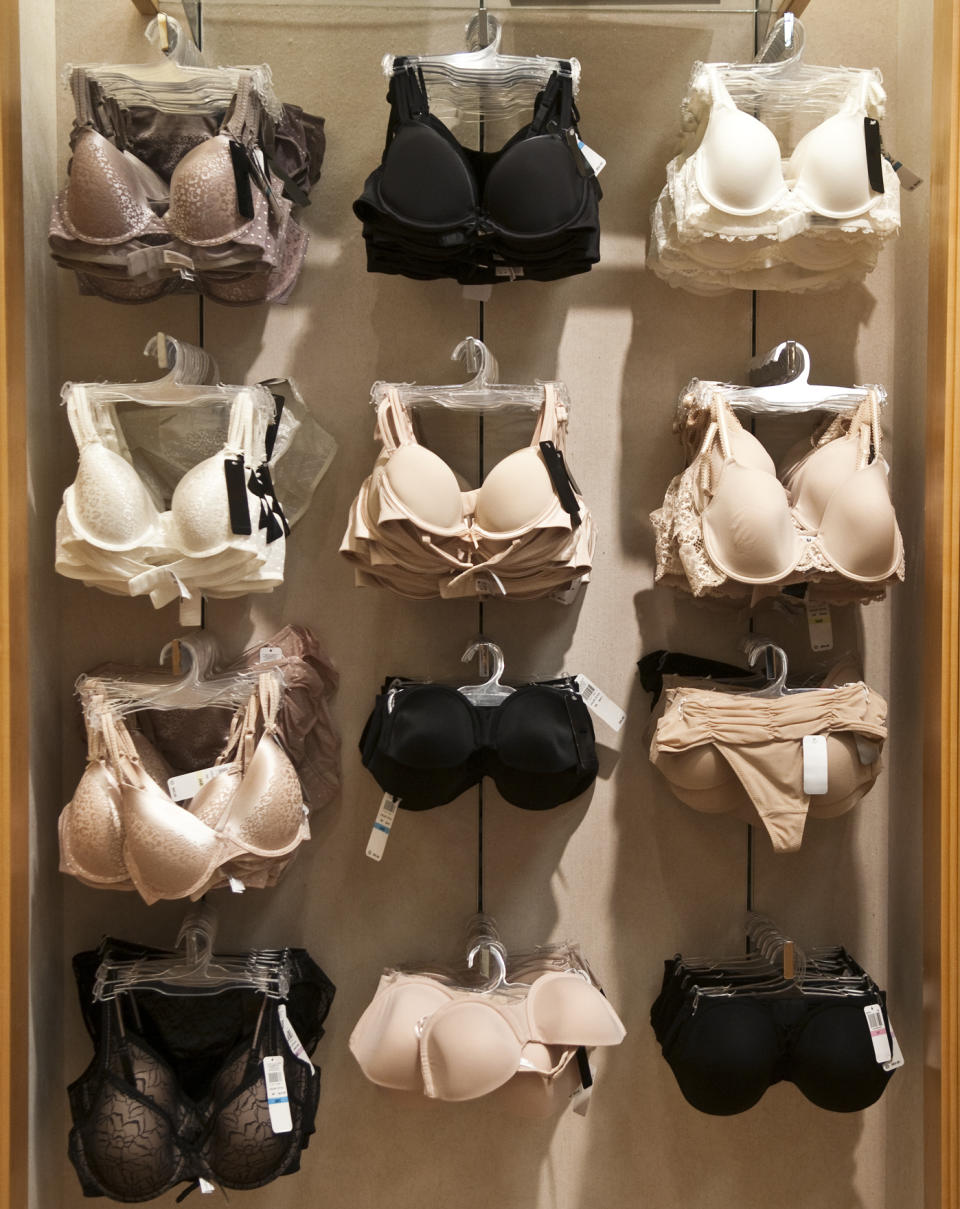 Assorted bras displayed on a lingerie store wall, ranging in style and design