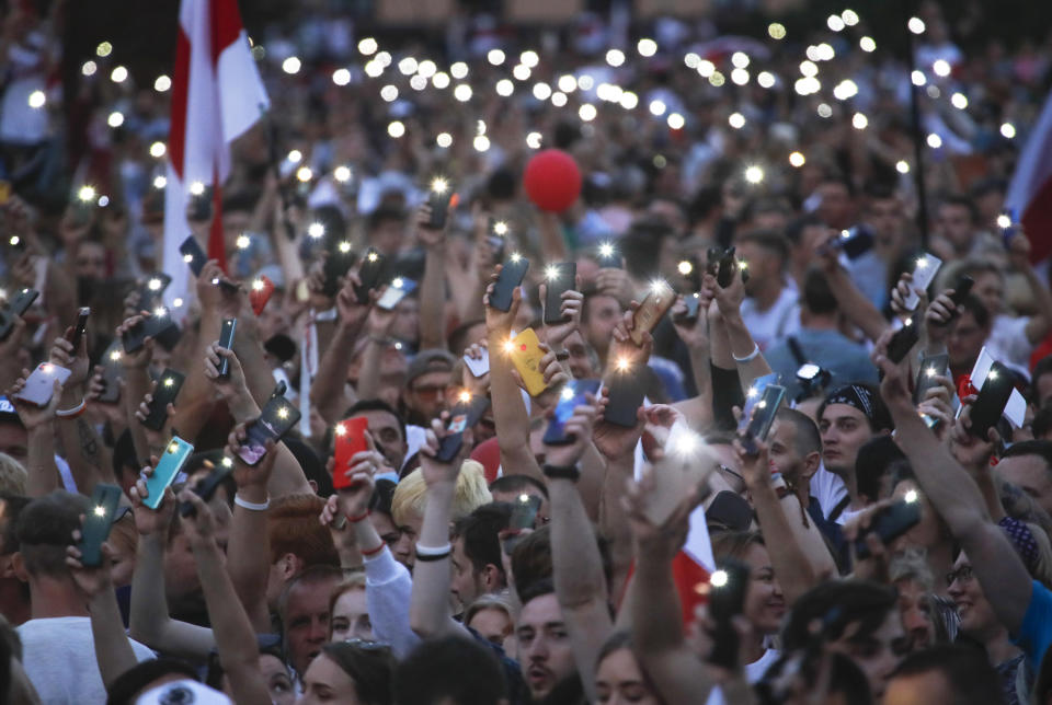 Belarusian opposition supporters light phones lights during a protest rally in front of the government building at Independent Square in Minsk, Belarus, Tuesday, Aug. 18, 2020. Workers at more state-controlled companies and factories took part in the strike that began the day before and has encompassed several truck and tractor factories, a huge potash factory that accounts for a fifth of the world's potash fertilizer output and is the nation's top cash earner, state television and the country's most prominent theater. (AP Photo/Dmitri Lovetsky)