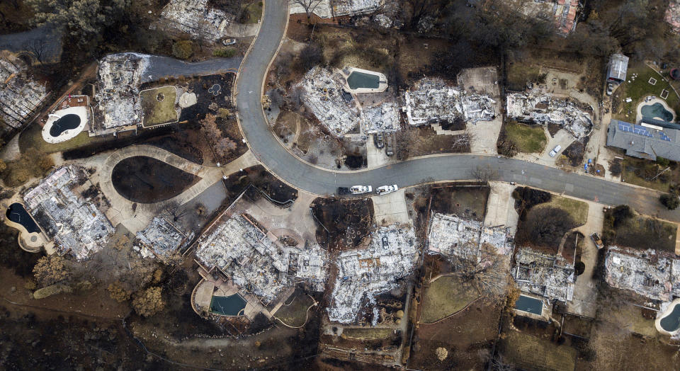 FILE - This Dec. 3, 2018, file photo, shows homes leveled by the Camp Fire line Valley Ridge Drive in Paradise, Calif. Attorneys representing 14 local governments said Tuesday, June 18, 2019, that they had reached a $1 billion settlement with California utility Pacific Gas & Electric for a series of fires dating to 2015. (AP Photo/Noah Berger, File)