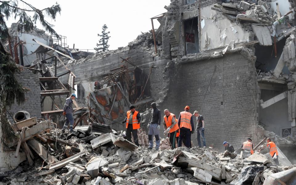 Emergency management specialists and volunteers remove debris from the theatre building - Reuters