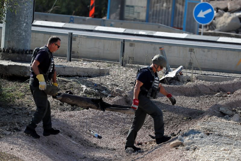 Israeli sappers carry the remains of a rocket in Kiryat Gat, southern Israel