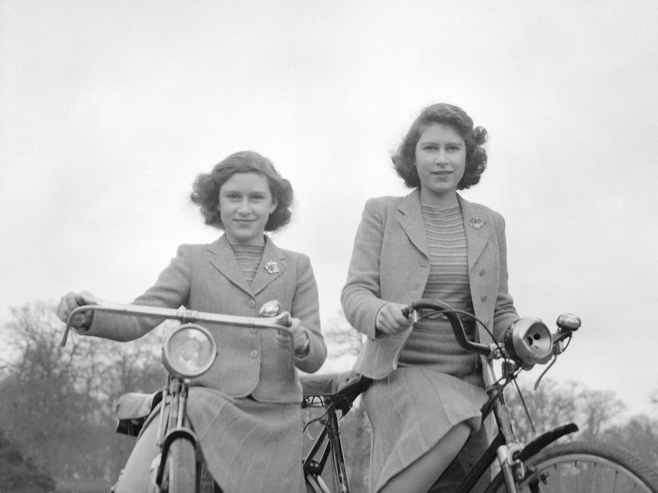 Princess Elizabeth and Princess Margaret pose on bicycles in Windsor, England on April 4, 1942.