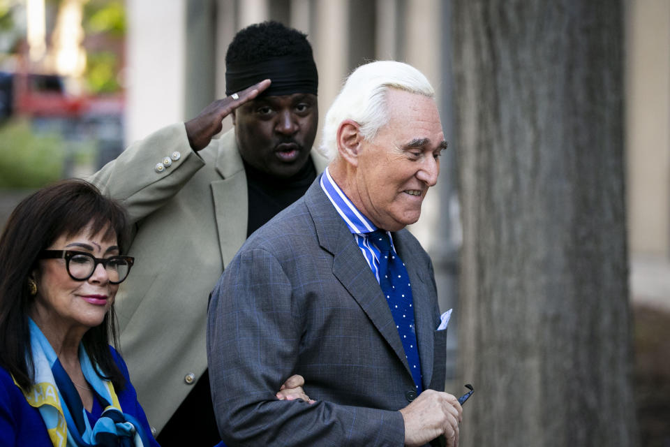 Roger Stone, and his wife Nydia, arrive as a man salutes him at Federal Court for his federal trial in Washington, Friday, Nov. 8, 2019. (AP Photo/Al Drago)