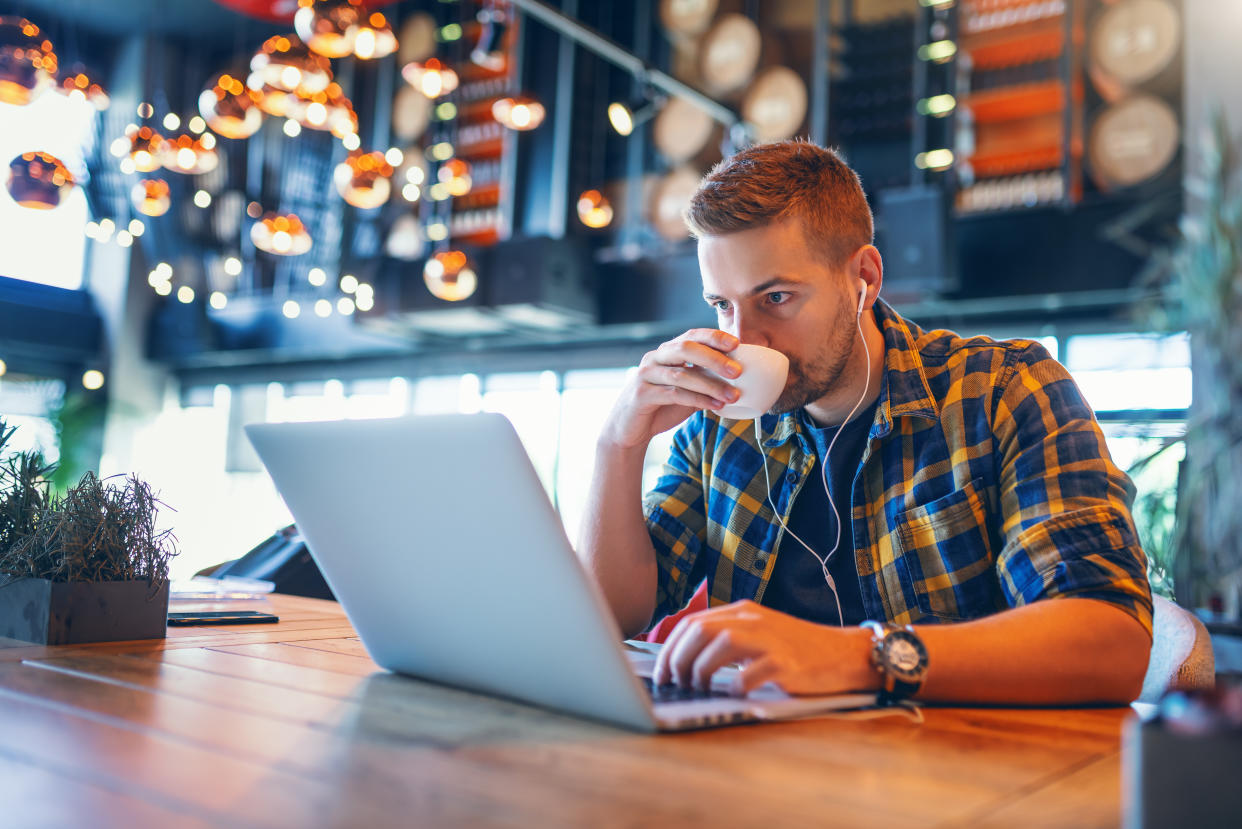 Man working on laptop in coffee shop