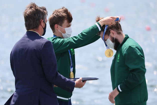 Ireland's Fintan McCarthy places a gold medal on teammate Paul O'Donovan at the medal ceremony for men's lightweight double sculls on July 28. (Photo: picture alliance via Getty Images)