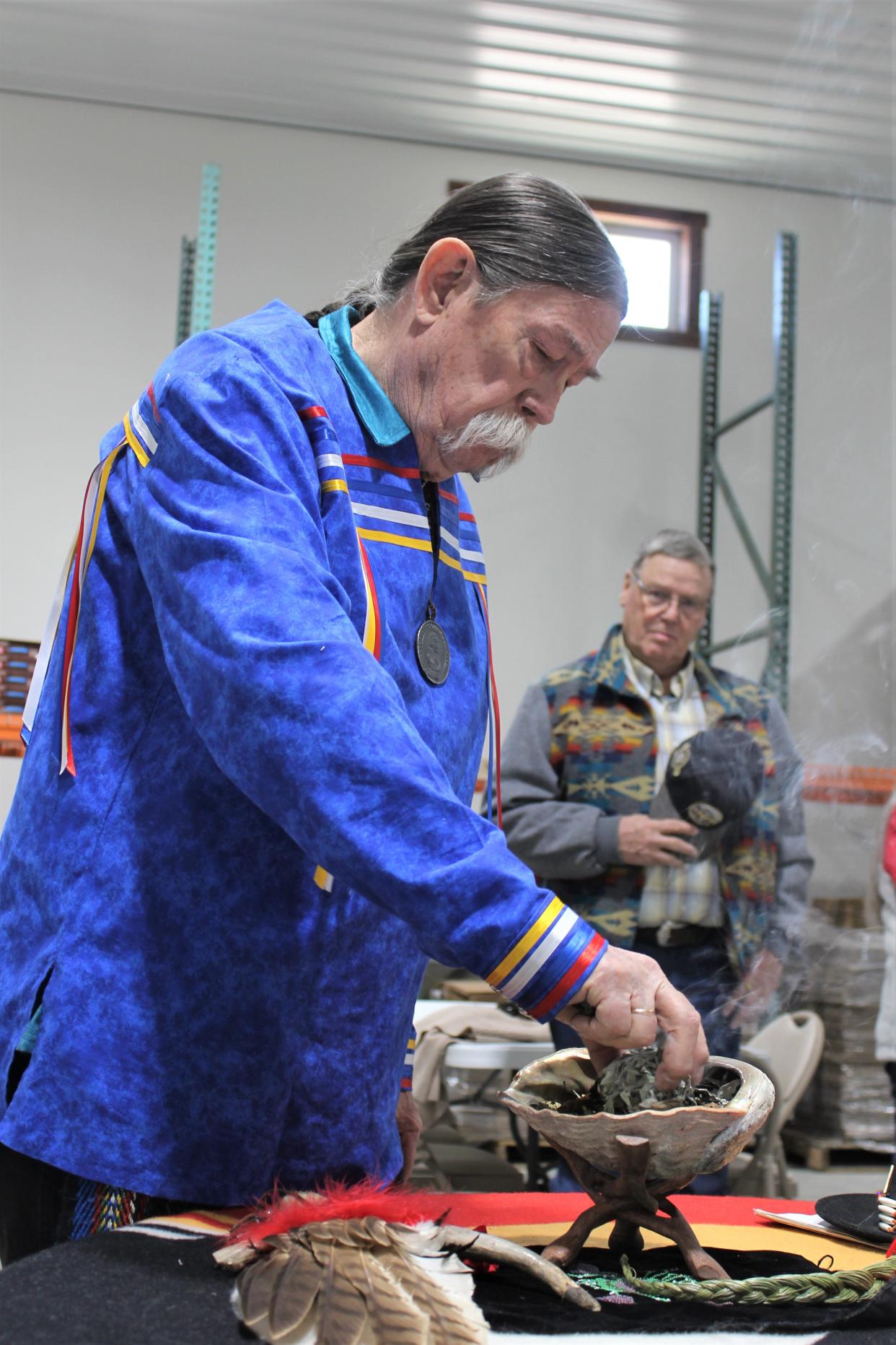 Little Shell tribal elder Daniel Pocha begins the smudge ceremony during the dedication of the tribe's new food distribution warehouse in Great Falls.