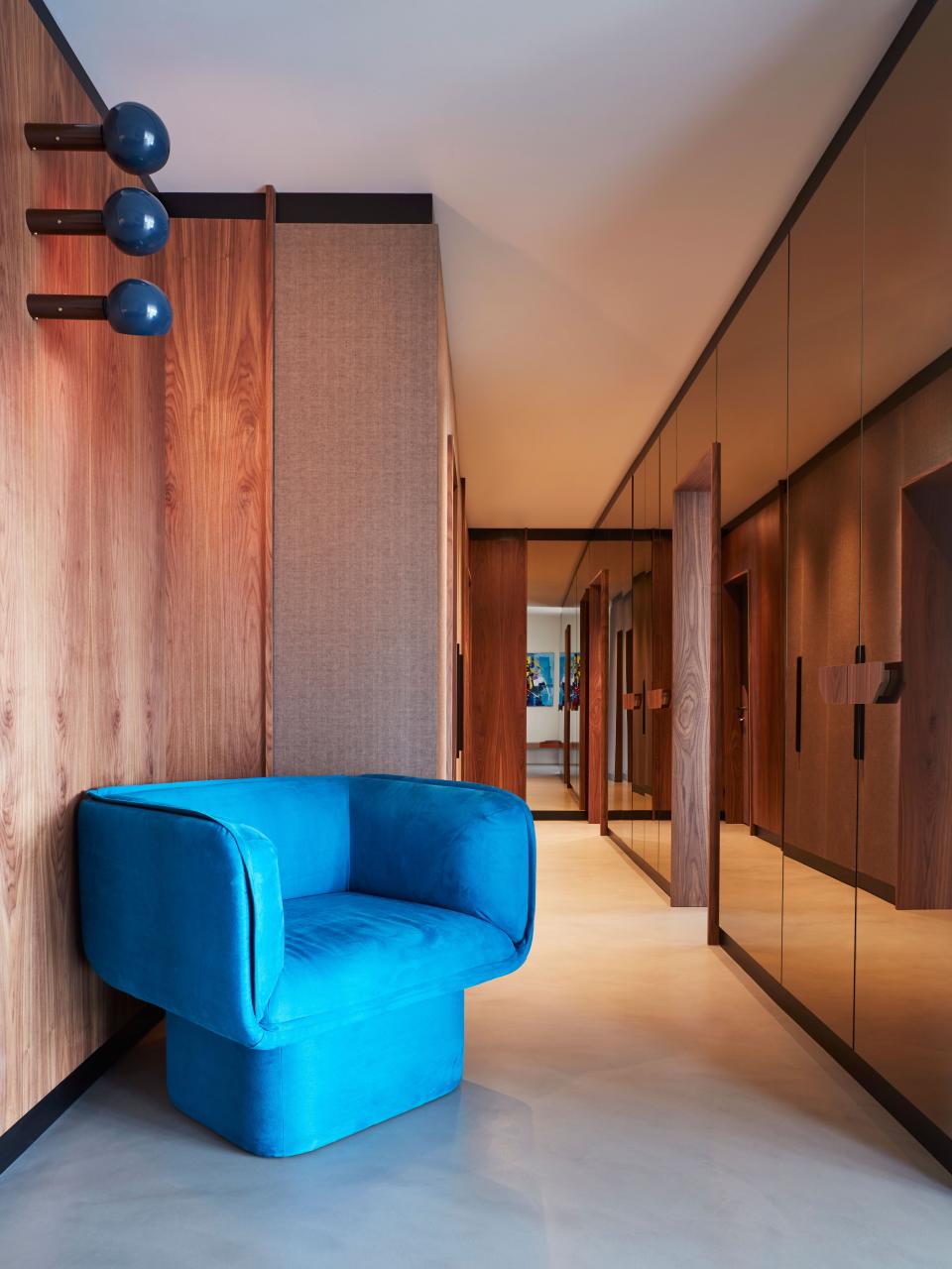 In the corridor, the bronze mirror and the walnut panels (all custom-made) add some warmth to the space.