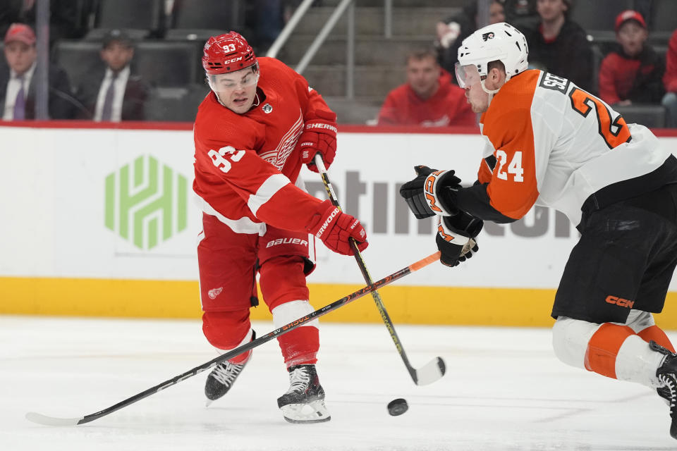 Detroit Red Wings right wing Alex DeBrincat (93) shoots the puck past Philadelphia Flyers defenseman Nick Seeler (24) during the second period of an NHL hockey game, Thursday, Jan. 25, 2024, in Detroit. (AP Photo/Carlos Osorio)