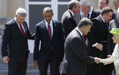 Canada's Prime Minister Stephen Harper (L) and U.S. President Barack Obama (2nd L) take their spots as Ukraine's President-elect Petro Poroshenko shakes hands with Britain's Queen Elizabeth during a family photo for the 70th anniversary of the D-Day landings in Benouville June 6, 2014. REUTERS/Kevin Lamarque