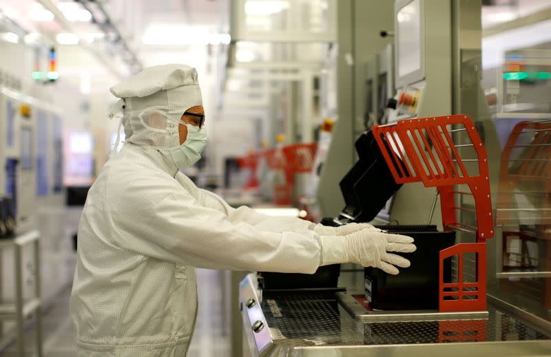 FILE PHOTO: Bosch employee holds semiconductor wafer in clean room in company manufacturing base in Reutlingen