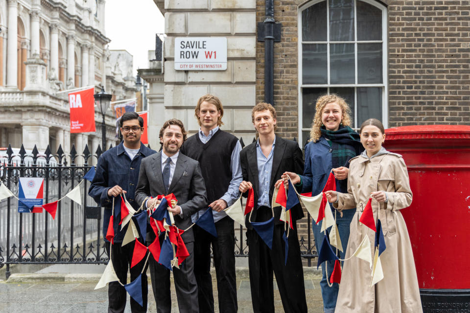 Apprentice tailors holding wool bunting on Savile Row