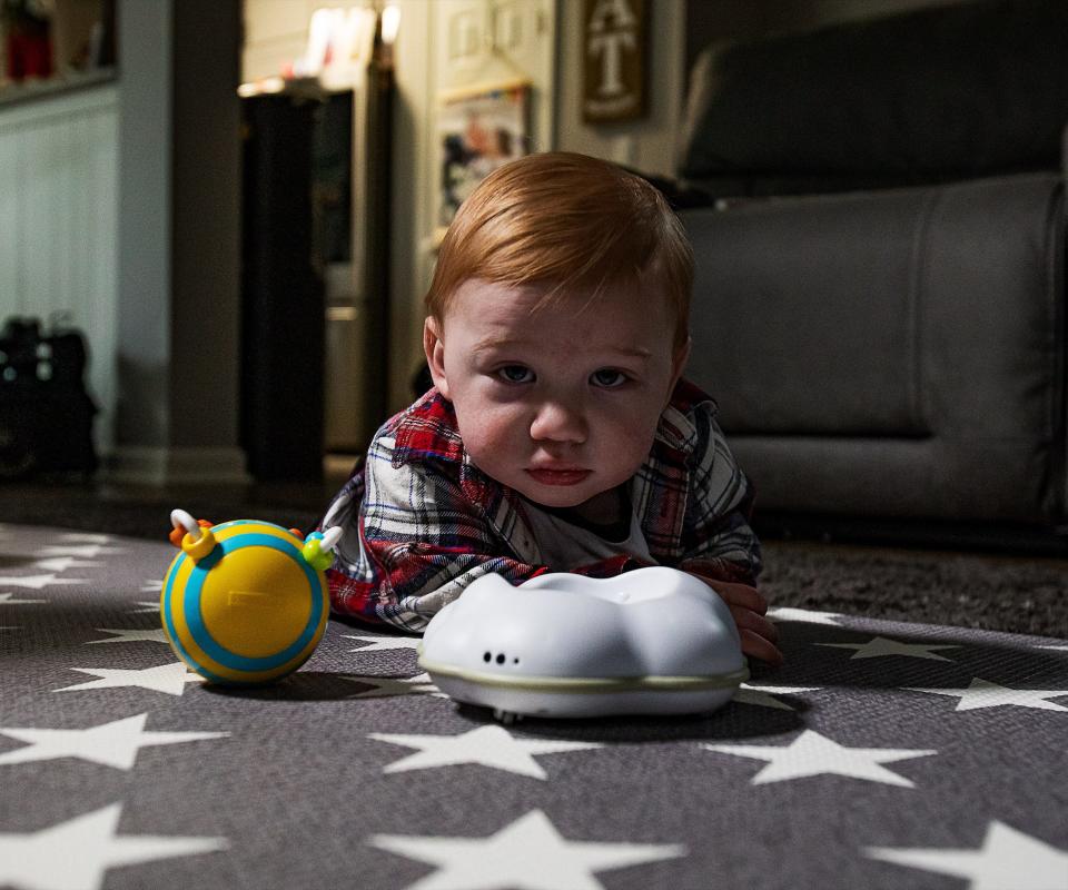 Wesson Keene, 1, looks skeptically at the camera while playing with a toy during a recent therapy session at his home in Lexington, Ky. Wesson has faced many challenges in his first year. Wesson's father died of COVID-19 complications near the time of his premature birth.