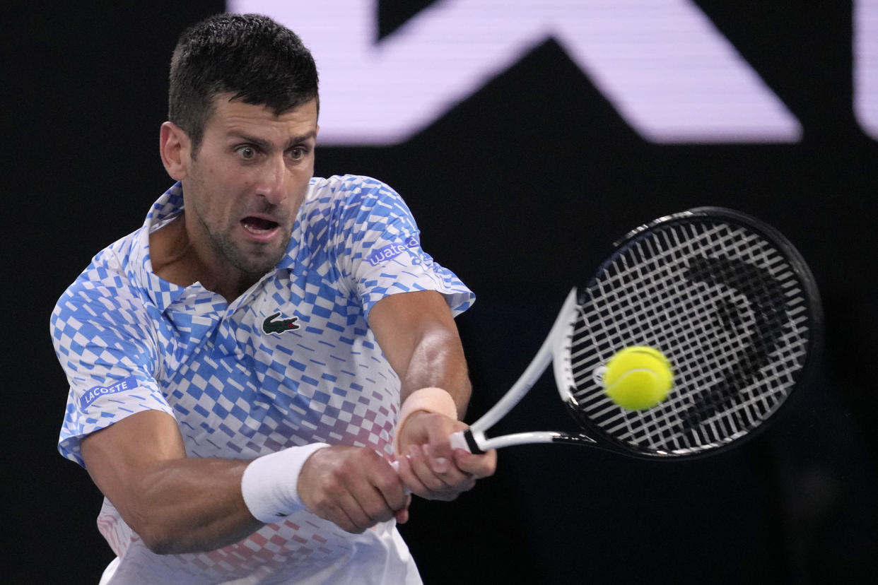 Novak Djokovic of Serbia plays a backhand return to Stefanos Tsitsipas of Greece during the men's singles final at the Australian Open tennis championship in Melbourne, Australia, Sunday, Jan. 29, 2023. (AP Photo/Dita Alangkara)