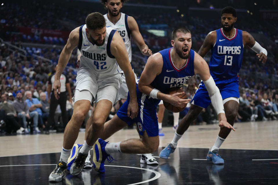 Dallas Mavericks forward Maxi Kleber (42) fouls LA Clippers center Mason Plumlee (44) during the first half of Game 1 of an NBA basketball first-round playoff series in Los Angeles, Sunday, April 21, 2024. (AP Photo/Ashley Landis)