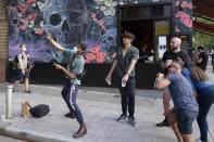 A man takes photos with friends outside a bar in the Hell's Kitchen neighborhood of New York, Friday, May 29, 2020, during the coronavirus pandemic. People are beginning to gather in small groups as the city begins to reopen. (AP Photo/Mark Lennihan)