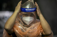 A Chinese tourist in from Shanghai, who arrived at Suvarnabhumi airport on a special tourist visa, adjusts her face shield, in Bangkok, Thailand, Tuesday, Oct. 20, 2020. Thailand on Tuesday took a modest step toward reviving its coronavirus-battered tourist industry by welcoming 39 visitors who flew in from Shanghai, the first such arrival since normal traveler arrivals were banned almost seven months ago. (AP Photo/Wason Wanichakorn)