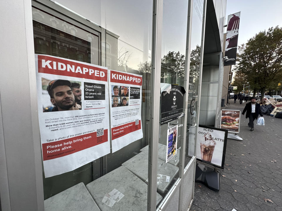 Carteles de personas tomadas como rehenes durante el ataque de Hamás son mostrados en una ventana del Museo Infantil Judío, el viernes 3 de noviembre de 2023, en Brooklyn, Nueva York. (AP Foto/Bebeto Matthews)