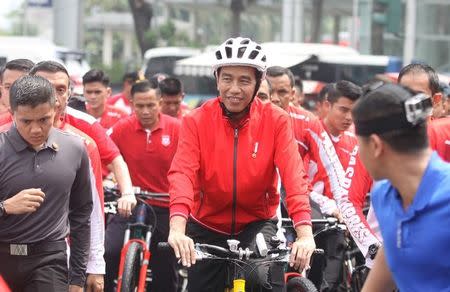FILE PHOTO: Indonesia's President Joko Widodo rides his bike during Car Free Day in central Jakarta, Indonesia August 20, 2017 in this photo taken by Antara Foto. Antara Foto/Reno Esnir/ via REUTERS/File Photo