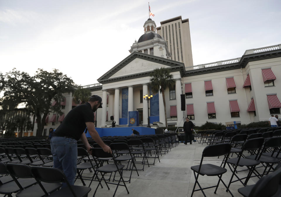 A worker arranges chairs outside of the Capitol building in preparation for the inauguration of Florida Gov.-elect Ron DeSantis and other officials, Monday, Jan. 7, 2019, in Tallahassee, Fla. The swearing in ceremony is Tuesday. (AP Photo/Lynne Sladky)