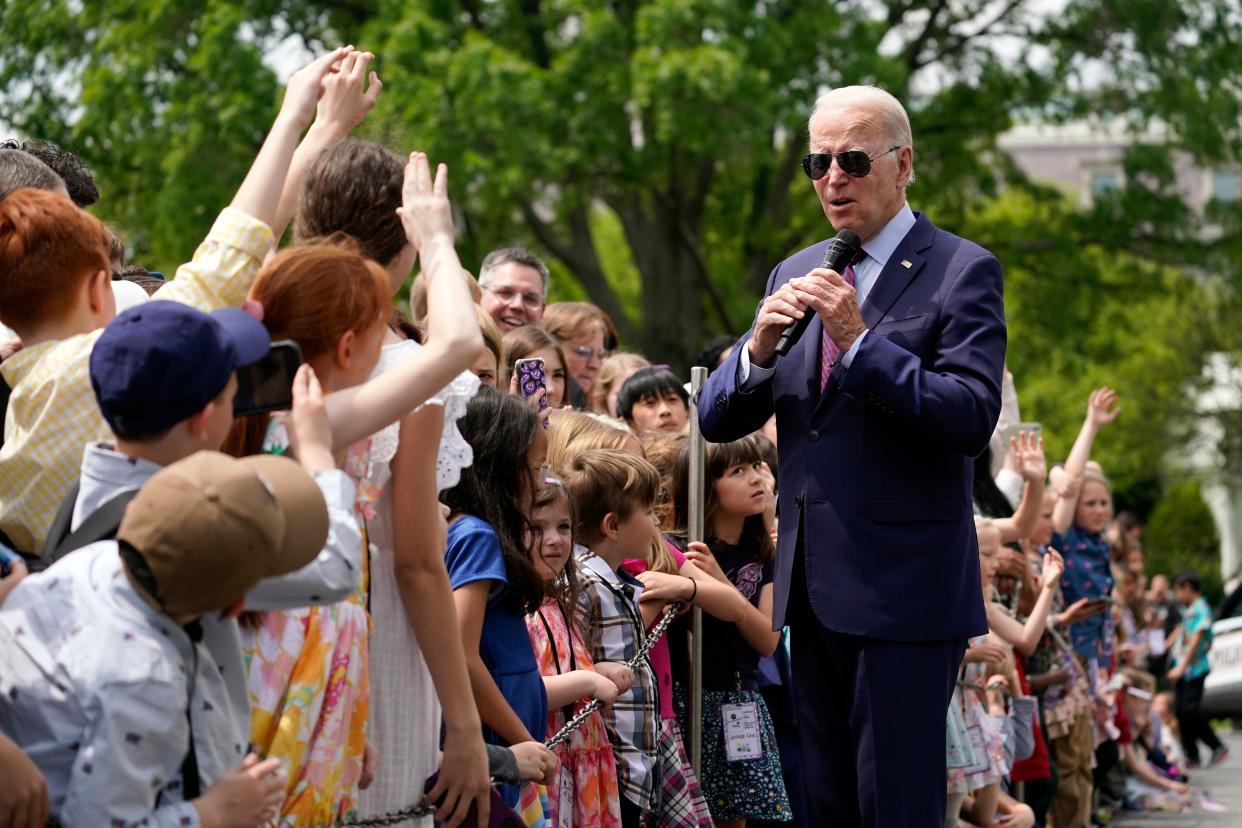 President Joe Biden speaks to a crowd of children.