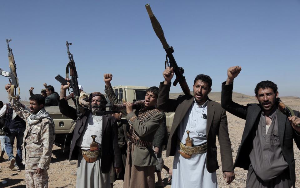 Houthis raise their rifles during a tribal rally against air attacks carried out by the US  on sites in Yemen