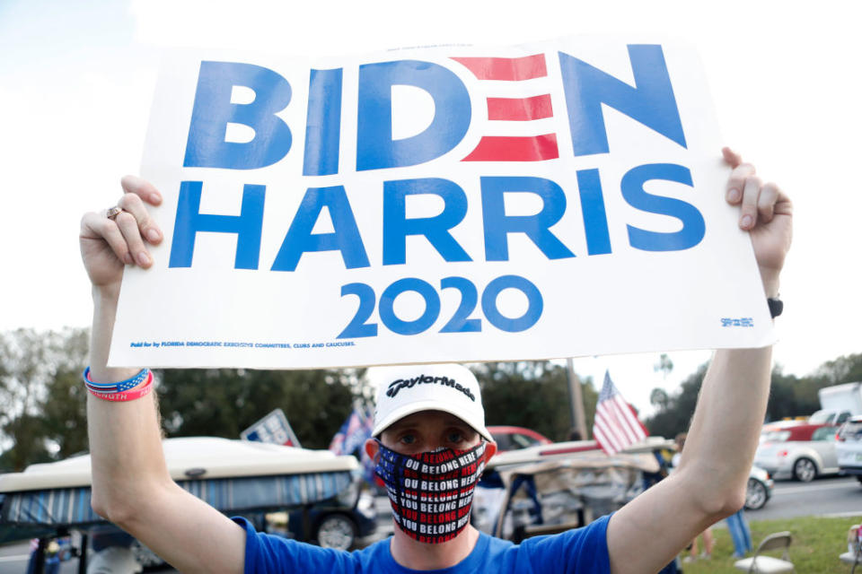 A man is holding a Biden Harris 2020 sign.