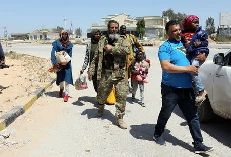 Members of Libyan internationally recognised government forces evacuate an African family during the fighting with Eastern forces, at Al-Swani area in Tripoli, Libya April 18, 2019. REUTERS/Ahmed Jadallah