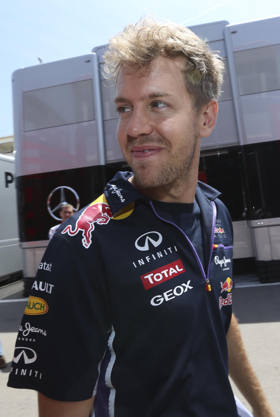 Red Bull driver Sebastian Vettel of Germany smiles in the paddock at the Catalunya racetrack in Montmelo, near Barcelona, Spain, Thursday, May 8, 2014. Red Bull will be counting on making strides after a dismal start to Sebastian Vettel's title defense. Vettel has yet to finish better than third place, and has twice been ordered by his team to let new teammate Daniel Ricciardo pass him for higher finishes in the last two races. The Formula One race will be held on Sunday. (AP Photo/Luca Bruno)