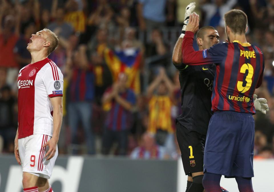 Ajax's Kolbeinn Sigthorsson (L) reacts after missing a penalty as Barcelona's Gerard Pique (R) congratulates goalkeeper Victor Valdes during their Champions League soccer match at Camp Nou stadium in Barcelona September 18, 2013. REUTERS/Albert Gea (SPAIN - Tags: SPORT SOCCER)