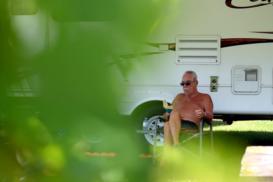 Erle Davidson, of Ontario, Canada, sits in the shade of his fifth wheel and reads in the mid-afternoon sun Friday, July 23, 2016 at the Cottonwood Campground.