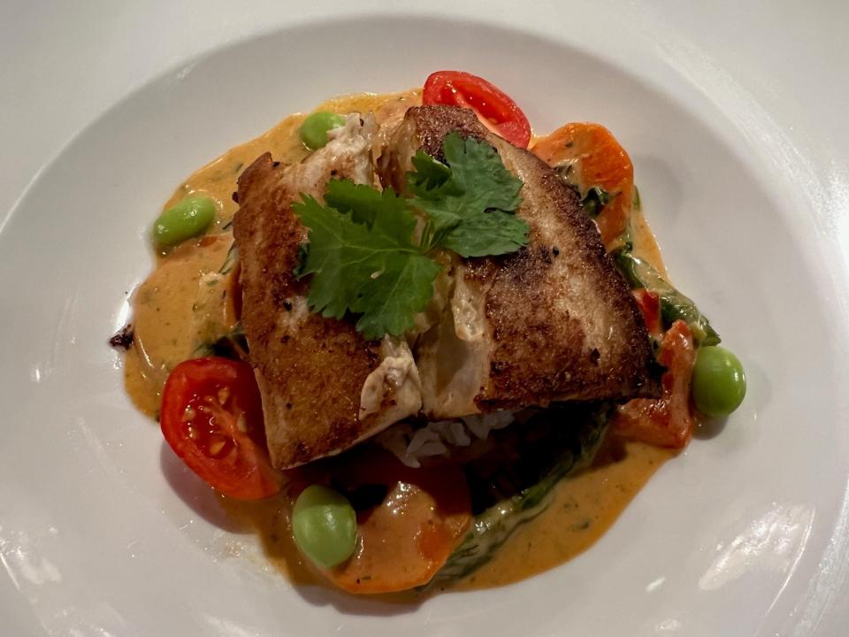 Pan-roasted mahi mahi comes with coconut curry sauce and ginger rice at Cooper's Hawk in Clive.