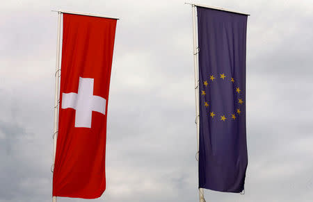 FILE PHOTO: The flags of the European Union and Switzerland flutter in the wind in Blotzheim, France June 27, 2017. REUTERS/Arnd Wiegmann/File photo