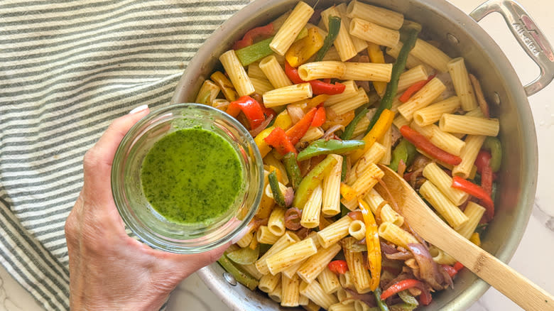 hand adding dressing to skillet