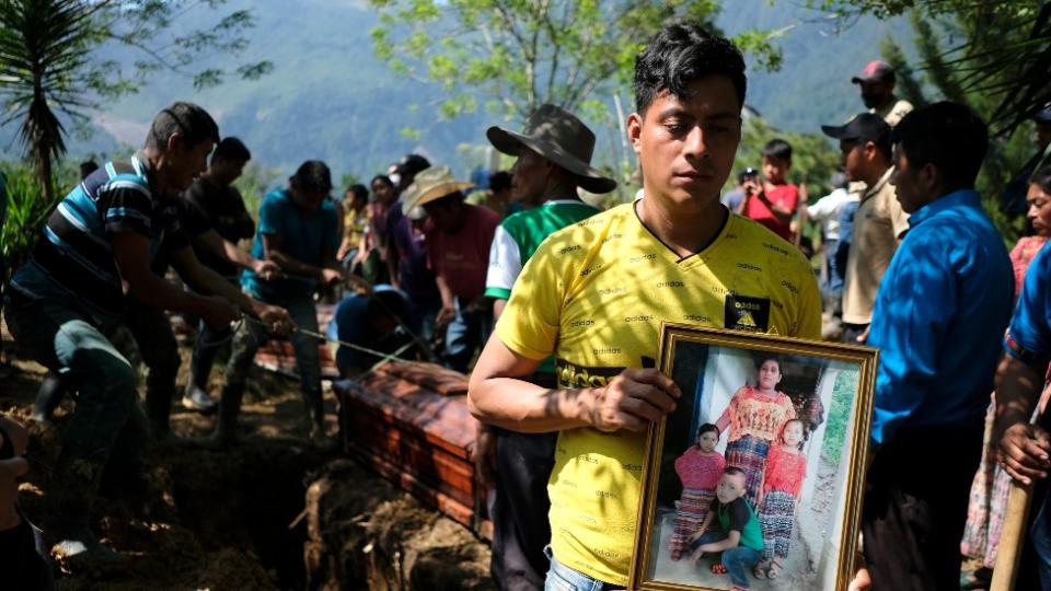 Carlos Humberto Suram Lxim lleva una foto de su esposa y sus tres hijos pequeños que fallecieron en un deslizamiento de tierra en la comunidad de Quejá, San Cristobal Verapaz, Guatemala.