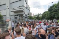 People queue outside the Belarusian embassy to cast their votes during the presidential election in Warsaw