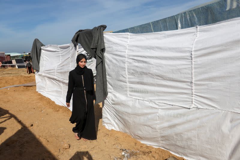 Raghad Abu Nadi, a displaced Palestinian girl whose father was killed in Israeli fire, walks outside her family makeshift shelter, in Rafah in the southern Gaza Strip