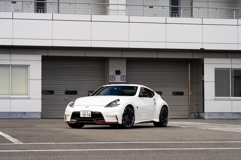 a white 2022 nissan fairlady z parked in front of a closed garage door