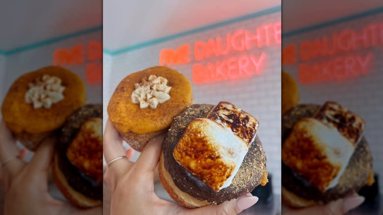 women's hand with two donuts