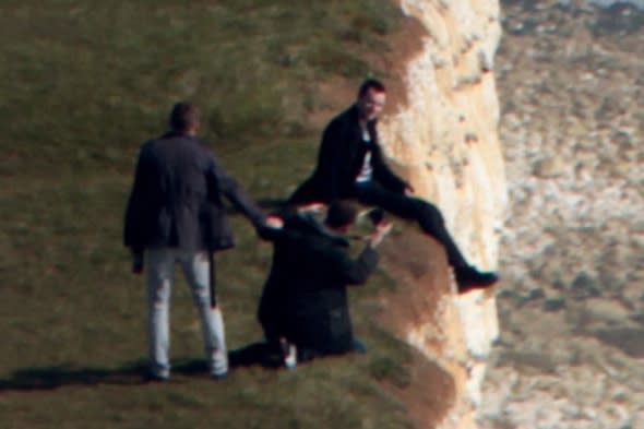 This is the shocking moment when a reckless man was spotted posing for a picture while dangling his legs over a crumbling 500ft cliff face.  Photographer Martin Stitchener, 40, said he was 'stunned' to see the man sitting perilously close to the edge of Britain's highest chalk cliffs.The daredevil and a group of friends were taking it in turns to perch above the steep drop at the famous beauty spot Beachy Head, East Sussex.  SEE OUR COPY FOR DETAILS.Pictured: The male sat on the side of the cliff with his legs dangling over.  This is the view of cliffs at Beachy Head.© Martin Stitchener/Solent News & Photo AgencyUK +44 (0) 2380 458800