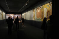 People admire Gustav Klimt's painting "The Beethoven Frieze" (1902) on display at the exhibition "Klimt. The Secession and Italy" at the Museum of Rome, in Palazzo Braschi, Rome, during a press preview, Tuesday, Oct. 26, 2021. The exhibition, that explores Klimt's period in Italy, will be open to visitors from Oct.27, 2021 to March 27, 2022. (AP Photo/Andrew Medichini)