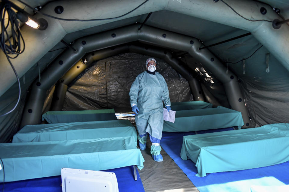 Medical personnel works inside one of the emergency structures that were set up to ease procedures outside the hospital of Brescia, Northern Italy, Tuesday, March 10, 2020. For most people, the new coronavirus causes only mild or moderate symptoms, such as fever and cough. For some, especially older adults and people with existing health problems, it can cause more severe illness, including pneumonia. (Claudio Furlan/LaPresse via AP)