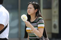 <p>A woman holds a portable fan at a business district in Tokyo, July 23, 2018. (Photo: Koji Sasahara/AP) </p>