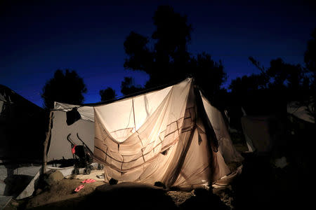 A tent is illuminated at a makeshift camp next to the Moria camp for refugees and migrants on the island of Lesbos, Greece, September 18, 2018. REUTERS/Giorgos Moutafis/File Photo