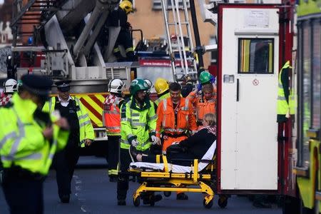 Emergency personnel rescue a woman trapped on the top floor of a bus after it crashed into a shop on Lavender Hill in Clapham, London, Britain August 10, 2017. REUTERS/Dylan Martinez